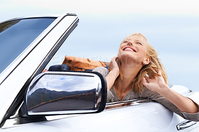 Buy stock photo Shot of a young couple enjoying a drive in a convertible