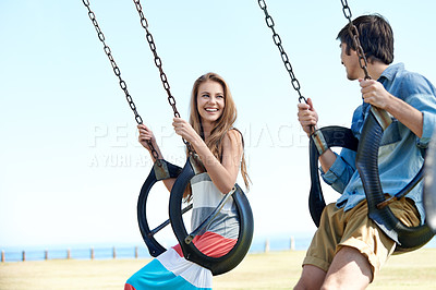 Buy stock photo Young couple, love or outdoor for swinging in nature, bonding or happy together in summer holiday by sea. Man, woman or vacation by swing set on romantic date, care or play by beach park in cape town