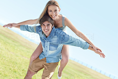Buy stock photo A playful young couple enjoying a beautiful day in the outdoors