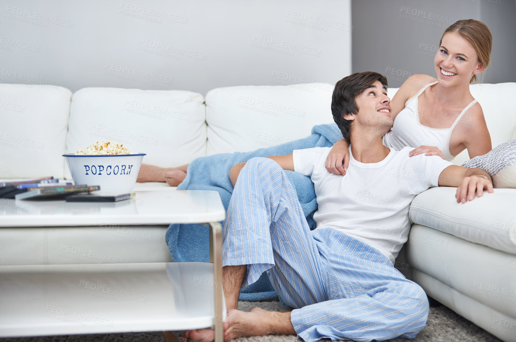 Buy stock photo Couple, film and lying with living room, popcorn and sofa for relaxation and love or smile. People, home and romance for comfortable valentines day date and happiness for video or streaming movie