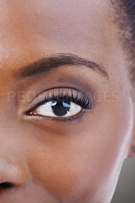 Buy stock photo Eyeshadow, makeup and black woman closeup with beauty and skincare on half of face. Eye, portrait and African model with healthy glow and shine on skin from dermatology, cosmetics or foundation