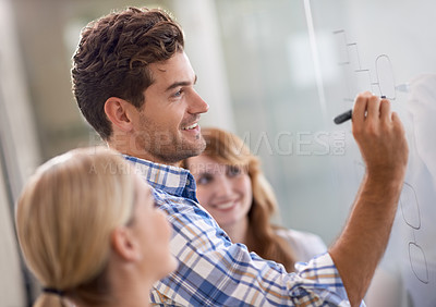 Buy stock photo A handsome young businessman brainstorming with his female colleagues
