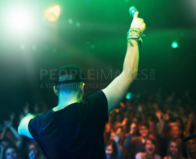 Buy stock photo Music, rock and stage with man and microphone singing for concert, festival and party event. Light, celebration and performance with singer and band at nightclub for disco, techno or new year show