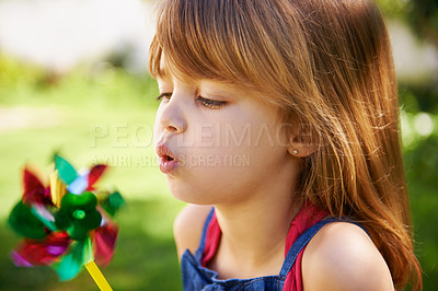 Buy stock photo Shot of a cute little girl playing with a pinwheel outside