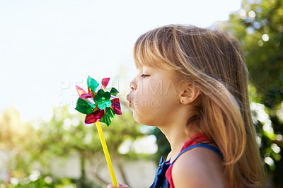 Buy stock photo Shot of a cute little girl playing with a pinwheel outside