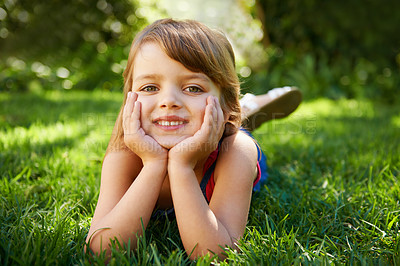 Buy stock photo Portrait, smile and child on grass at park to relax, cute and lying outdoor to travel in nature. Face, kid and happy girl on lawn for holiday, summer vacation and positive expression in Australia