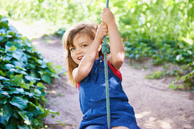 Buy stock photo Shot of an adorable little girl swinging on a rope