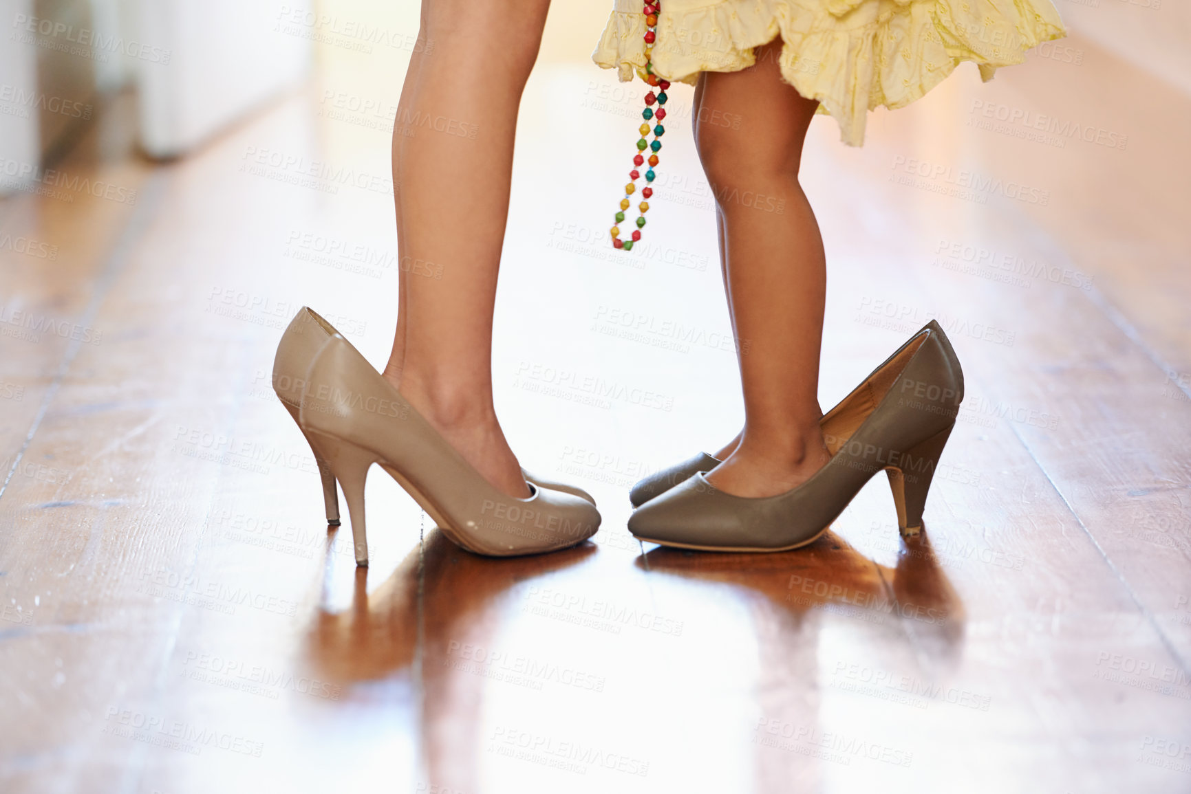 Buy stock photo Little girl, feet and big high heel shoes for growth, fun glamour or fashion on wood floor. Closeup of female person, child or sibling kids playing dress up in oversized footwear or growing childhood
