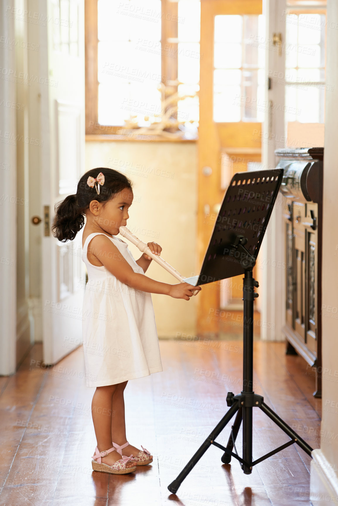 Buy stock photo Flute, girl and child playing in home for learning, education and reading music sheet to practice performance. Art, flutist and kid with talent, creative or hobby with instrument for sound at lesson