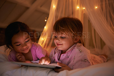 Buy stock photo Night, bed and girls with a tablet, games and playing for fun, happiness and relax together. Female kids, children and young people with technology, entertainment and cheerful with a smile or evening
