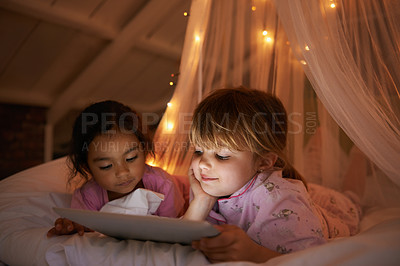 Buy stock photo Girls, bedroom and tablet for a movie, night and relax with pajamas, chilling and games at home. Female children, young people and kids with technology, bed or bonding with fun, playful and happiness