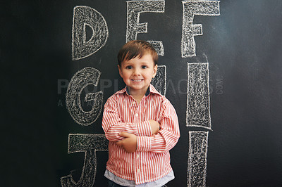 Buy stock photo Child, boy and portrait with smile by blackboard with letters, alphabet or drawing in classroom at school. Kid, student and happy for knowledge, learning and chalkboard with illustration or preschool