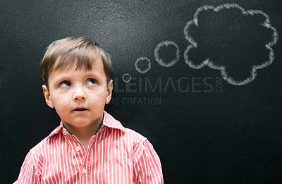 Buy stock photo Child, boy and thinking with thought bubble on blackboard for creative idea, drawing and illustration in classroom. Student, kid and face with daydreaming, contemplating and question with chalkboard