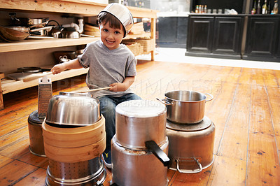 Buy stock photo Portrait, boy child and playing drum on a pot on a floor, happy and enjoying playful music. Face, creative and kid with pan for musical instrument, fun and carefree in a kitchen on the weekend
