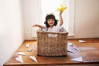 Buy stock photo A little boy playing with toy airplanes while sitting in a basket