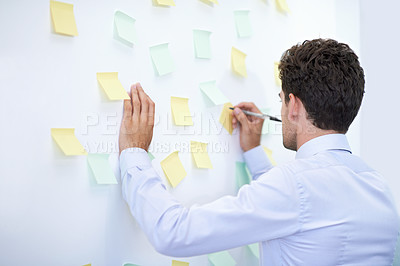 Buy stock photo Businessman, writing and sticky notes on wall for planning, brainstorming and project strategy with rear view. Entrepreneur, employee and ideas for agenda, schedule and proposal information at work