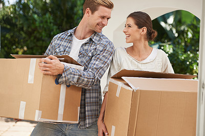 Buy stock photo Shot of a young couple carrying boxes into a new home together