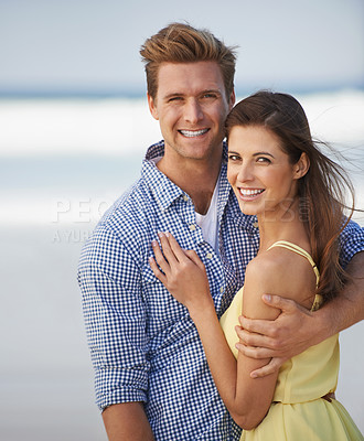 Buy stock photo A young couple embracing happily on the beach