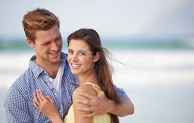 Buy stock photo Portrait, couple and smile for embrace, beach and romantic date on sunny afternoon in Spain. Hug, man and woman in love for kind relationship, fun dating and bonding together on weekend getaway