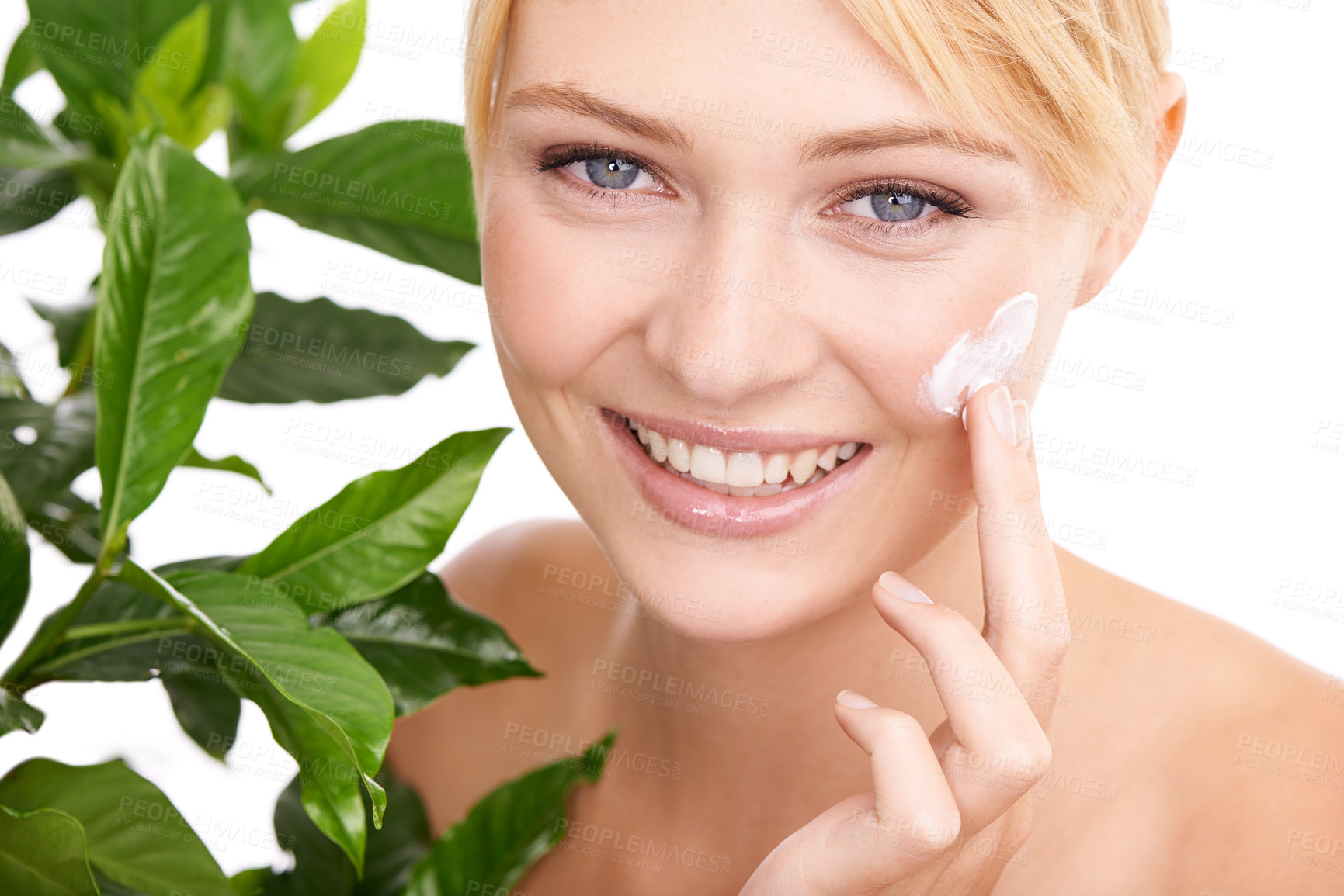 Buy stock photo Cream on face, leaves and woman with beauty for dermatology organic cosmetics and smile on white background. Portrait, lotion or sunscreen with green plant for eco friendly skincare and moisturizing