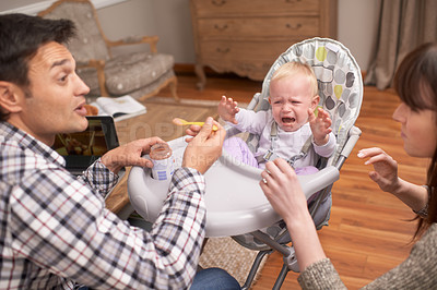 Buy stock photo A young father feeding his daughter some baby food