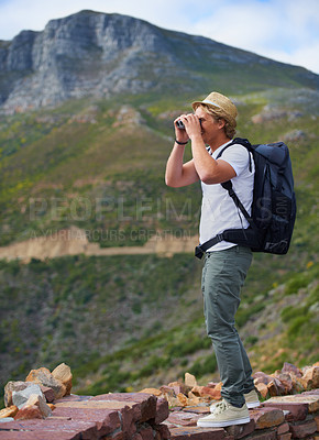 Buy stock photo Man, traveler and binoculars with backpack for sightseeing, outdoor travel or hiking on mountain in nature Young male person, hiker or tourist with bag or optical instrument for view, vision or scope