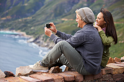 Buy stock photo Happy couple, selfie and photography in nature on mountain for picture, memory or outdoor vlog. Rear view of man and woman smile for photo, social media or bonding moment outside on cliff or wall