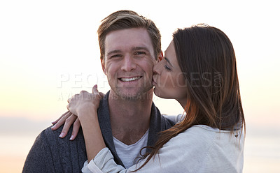 Buy stock photo Love, kiss and couple on beach at sunset for tropical holiday adventure, relax and bonding together. Commitment, happy man and woman on romantic date with ocean, evening sky and embrace on vacation.
