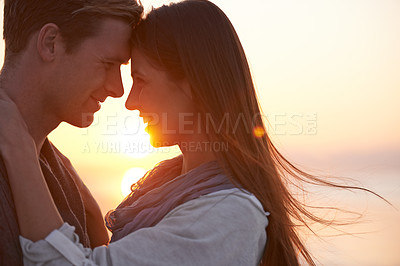 Buy stock photo A young couple enjoying a romantic moment together at the beach