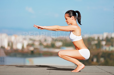 Buy stock photo Fitness, woman and body squat on roof top for workout, exercise or training in the city outdoors. Fit and active female squatting, stretching or exercising on floor for balance or healthy wellness