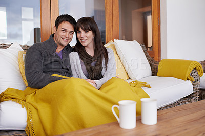 Buy stock photo Happy, love and portrait of couple on a sofa with trust, support or bonding with coffee and blanket at home. Smile, face or people in living room with security, safety and chilling together in house
