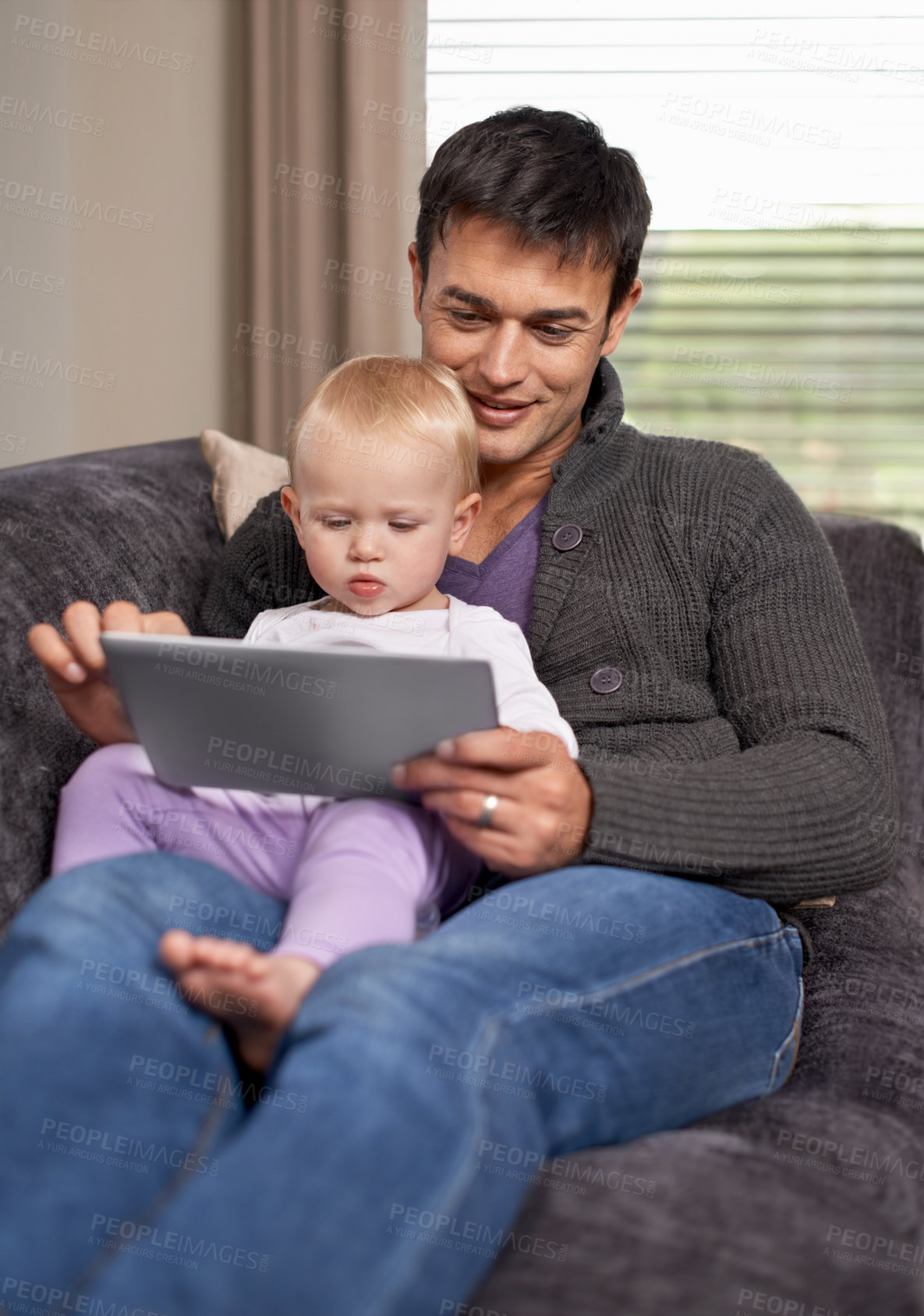 Buy stock photo A young father and his daughter playing on a digital tablet