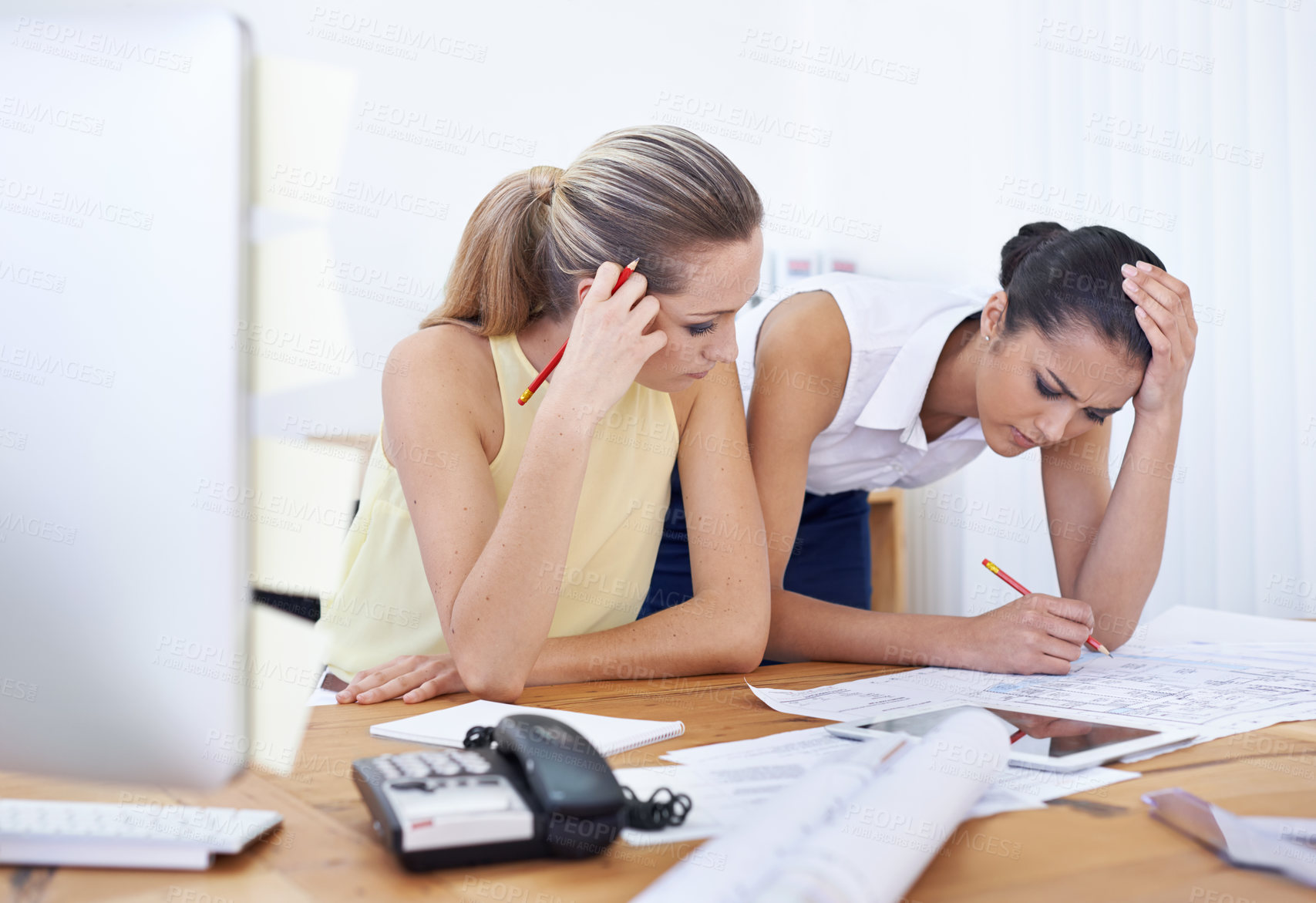 Buy stock photo Two young female architects working on some new designs