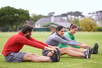 Buy stock photo Friends, sitting and stretching on field for exercise, training or happy for fitness with health in summer. People, men and woman with wellness with smile, body and workout group on lawn in Australia
