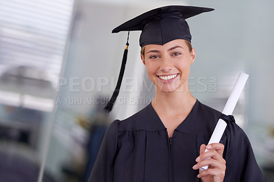 Buy stock photo Shot of a young woman in a graduation gown holding a diploma