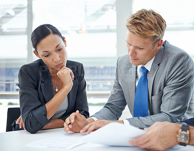 Buy stock photo Shot of businesspeople looking over documents