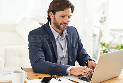 Buy stock photo A handsome businessman working on his laptop