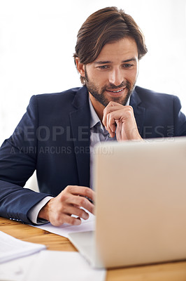Buy stock photo A handsome businessman working on his laptop at his desk