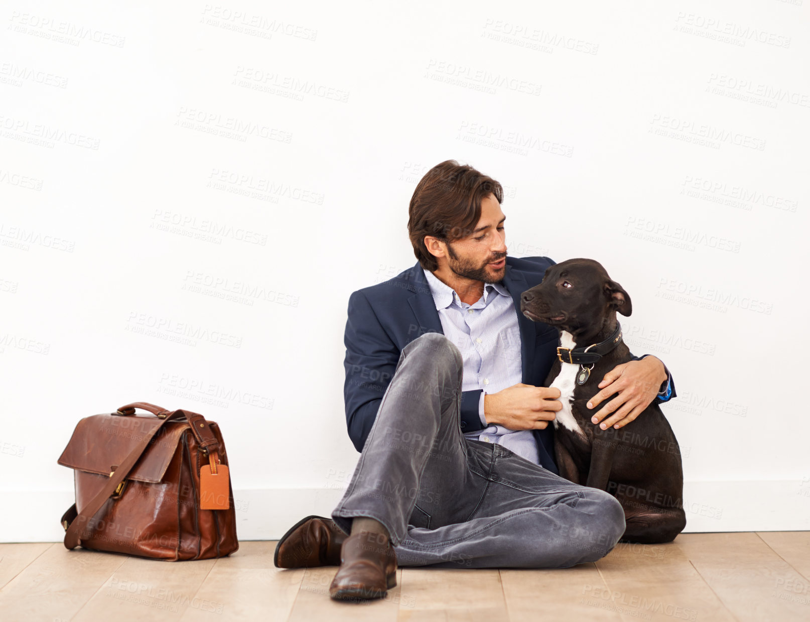 Buy stock photo Cute, bonding and happy businessman with dog by wall with positive attitude together. Career, briefcase and professional male person playing and scratching pet, puppy or animal on floor at home.