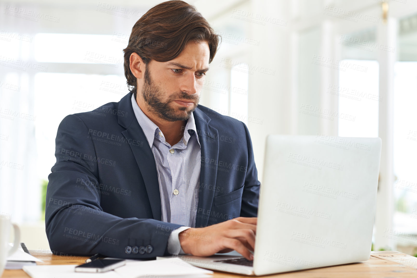 Buy stock photo An attractive businessman hard at work on his laptop