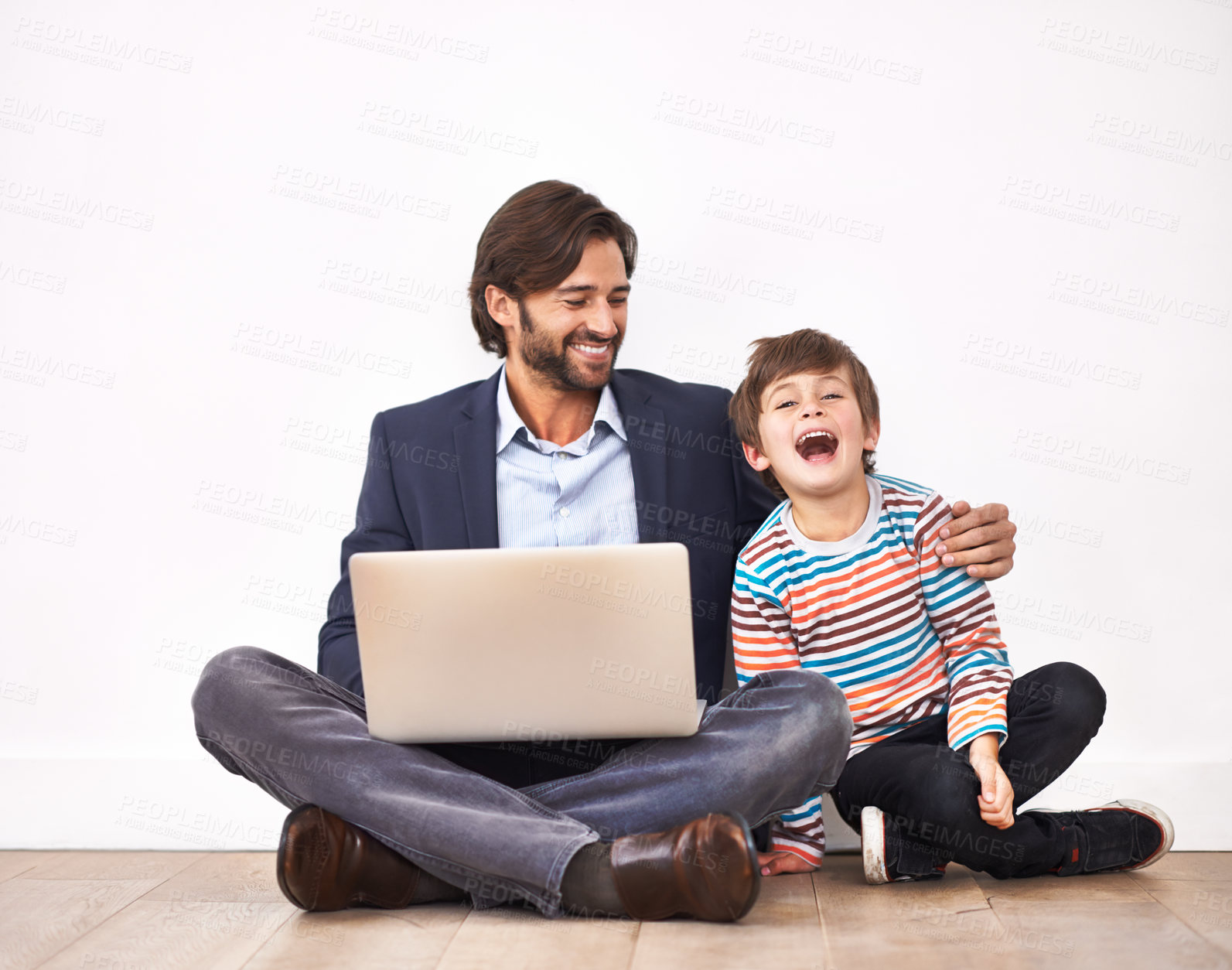 Buy stock photo A father and son sitting on the floor with a laptop