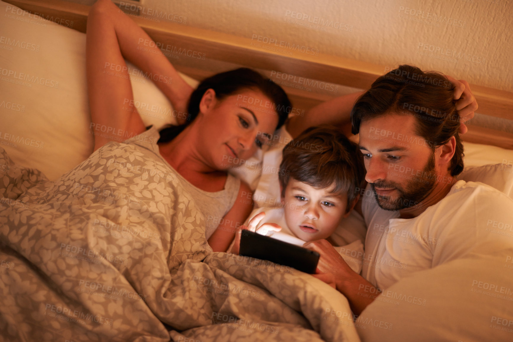Buy stock photo Family, together and movie on tablet in bed, digital and educational for learning of child. Parents, love and technology with connection to internet for bonding, mom and dad relax with son in bedroom