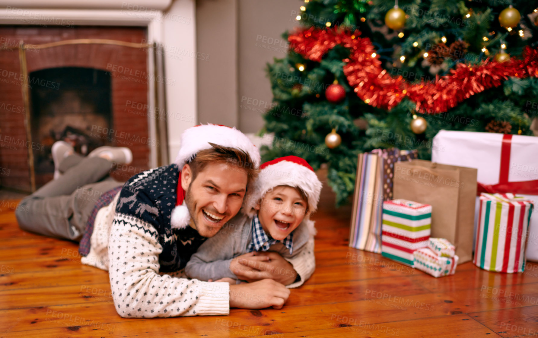 Buy stock photo Father, son and happy with portrait on christmas for celebration, playing and love on floor with santa hats. Family, man and child with smile, relax and enjoying holiday season in living room of home