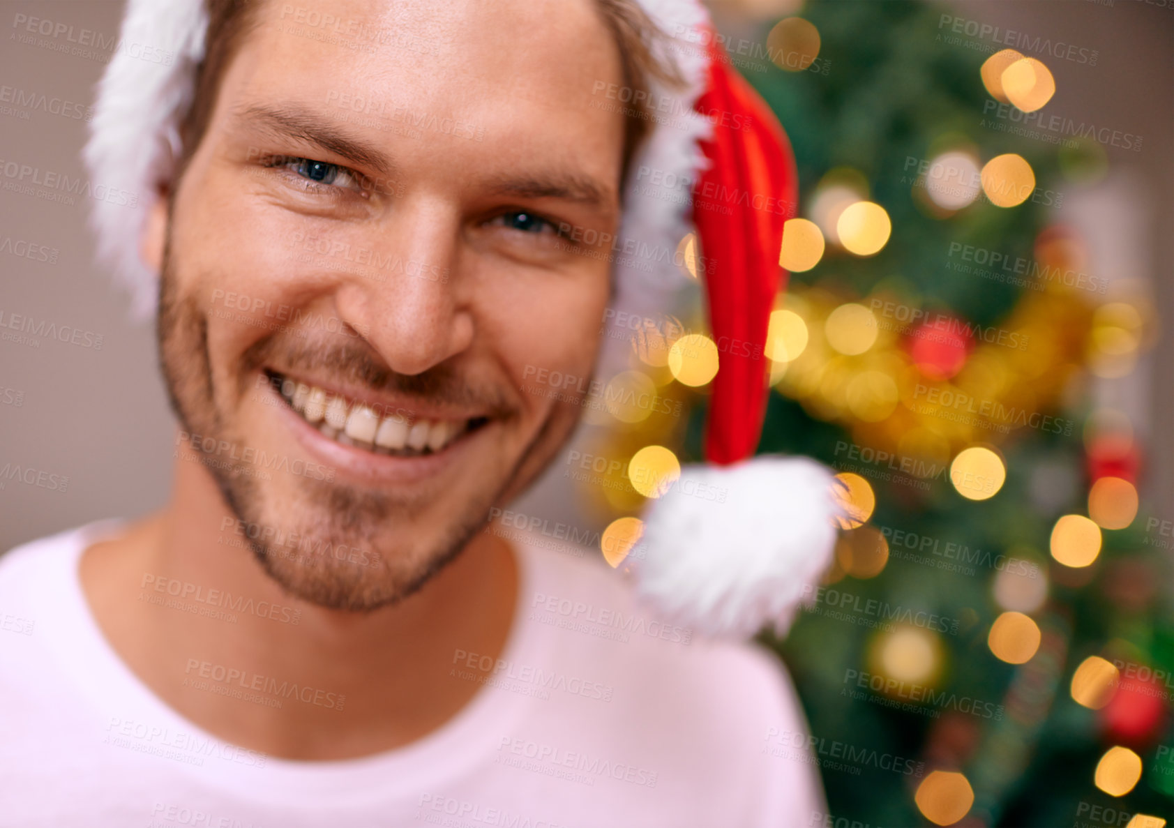 Buy stock photo Man, party hat and portrait by Christmas tree, celebration and smiling at home on religious holiday. Male person, happy and special decoration for festive vacation, tradition and cheerful for event