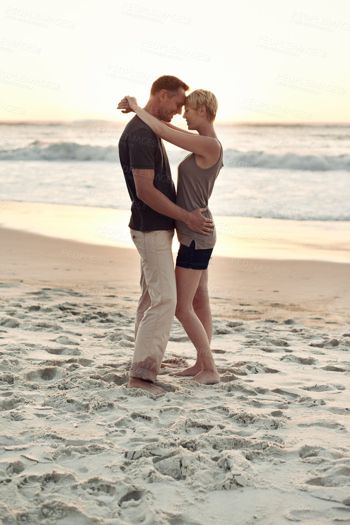 Buy stock photo Couple, together and beach with sunset for romance with peace in trip and vacation. Partners, embrace and relax in sea to enjoy, calm and smile for love of marriage in  honeymoon and holiday