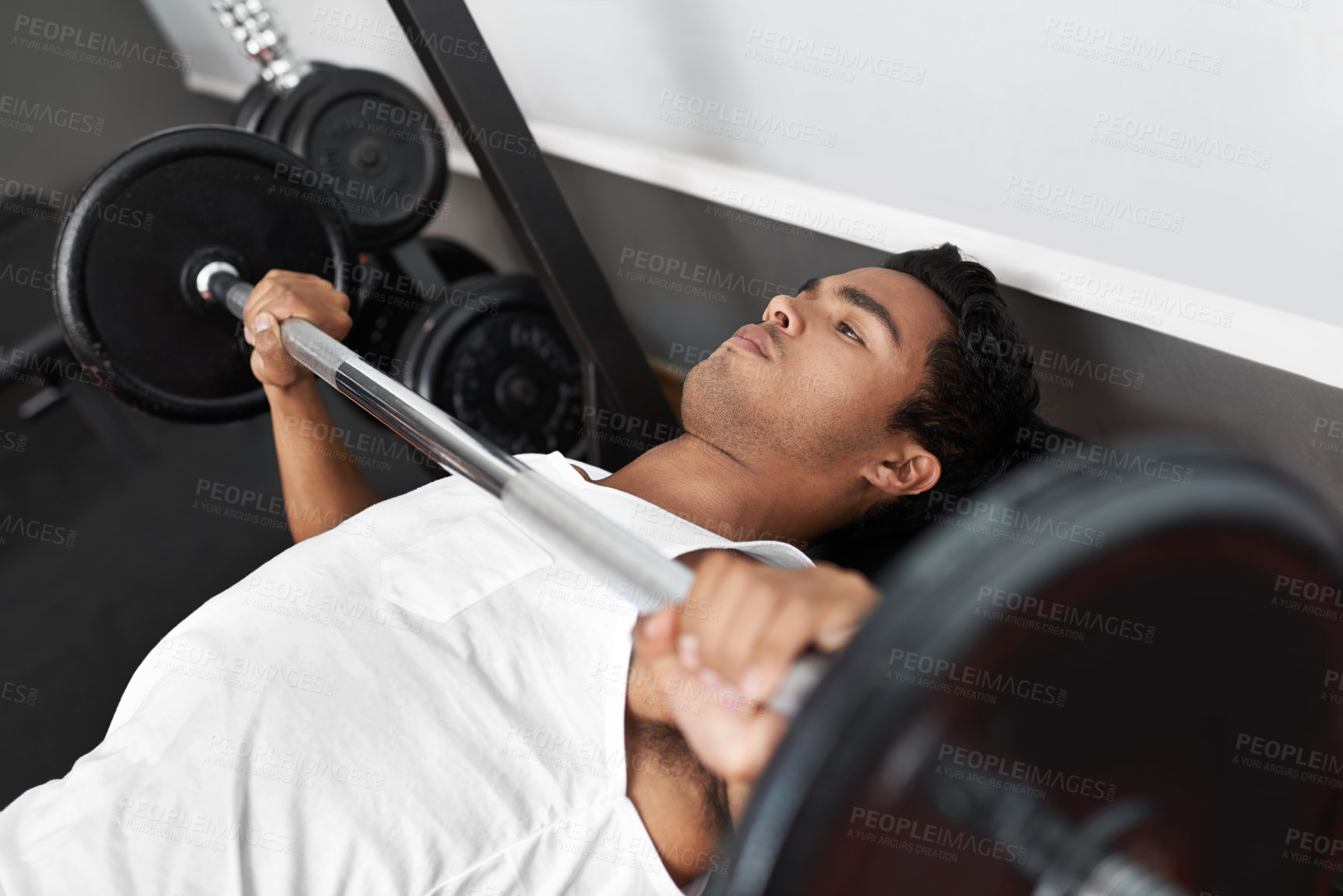 Buy stock photo A young ethnic man exercising in the gym