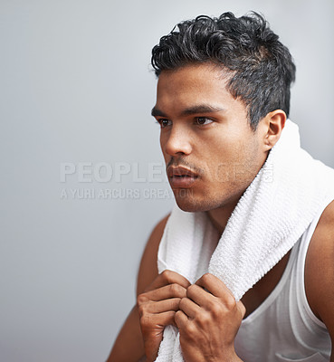 Buy stock photo Face, fitness and towel with man breathing in studio isolated on gray background for workout. Exercise, sweating and intensity with confident young athlete on break from training for performance