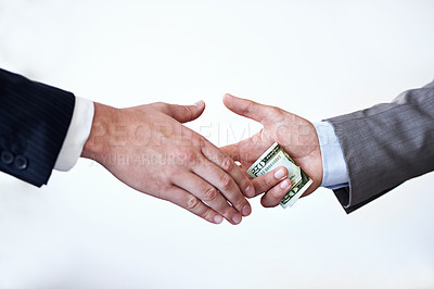 Buy stock photo Business people, money and handshake with bribe for agreement or deal on a white studio background. Colleagues or employees shaking hands with cash, bills or paper for secret, bribery or fraud