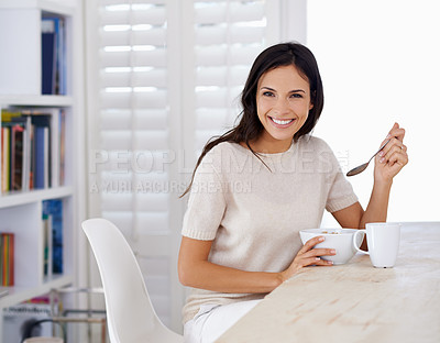 Buy stock photo Shot of a young woman eating breakfast 
