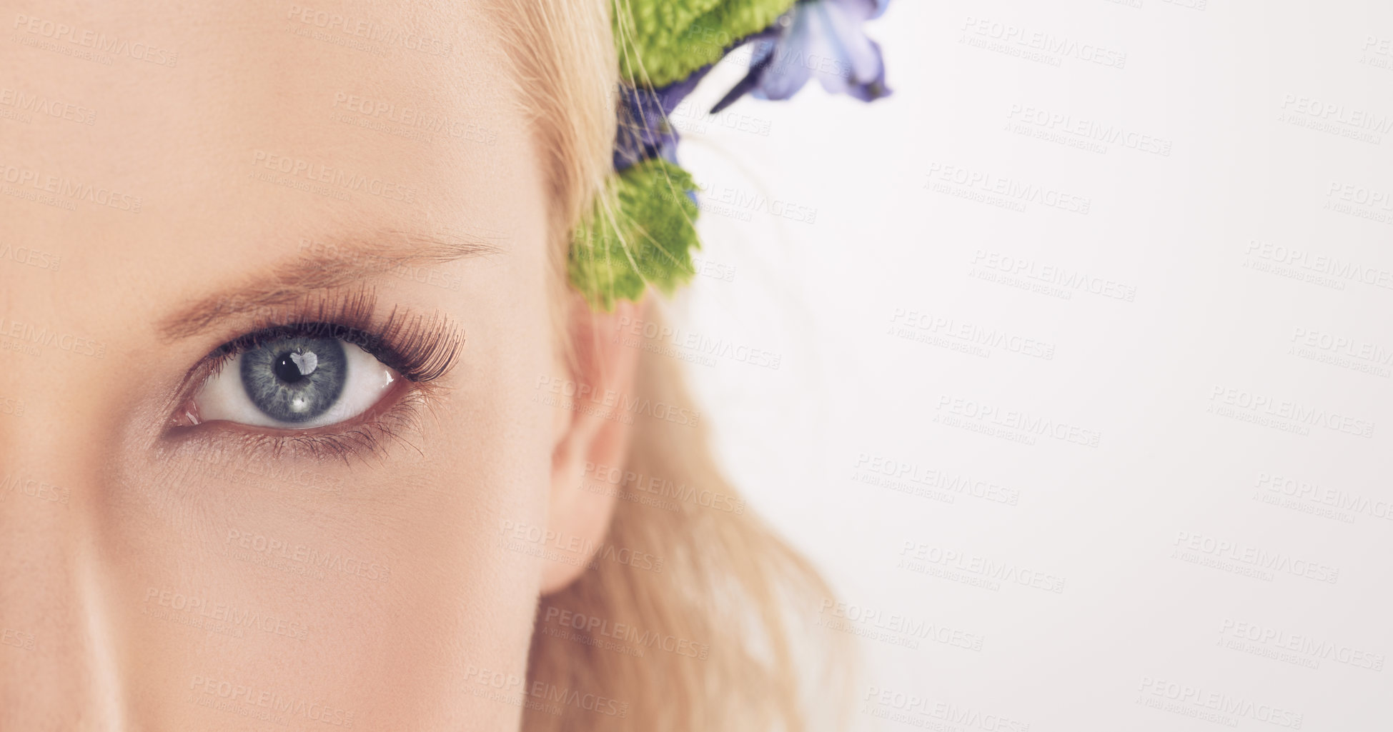 Buy stock photo Woman, flowers and half face in studio with beauty, makeup or cosmetics with eyelash extensions on mockup space. Model, person and portrait with collagen, skincare or glowing skin on white background